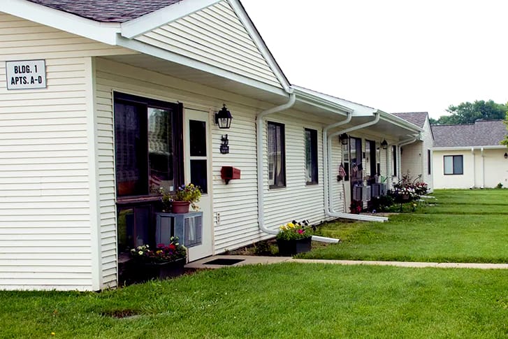 Exterior of a one-story white apartment building.